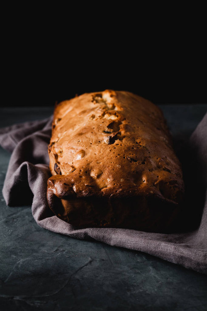 Fresh bread with dried fruits on dark rustic background - Foto, Imagem