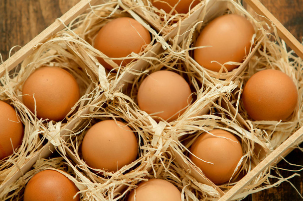 Huevos crudos en caja de madera
 - Foto, Imagen