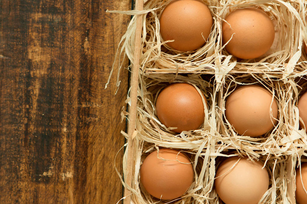 Huevos crudos en caja de madera
 - Foto, imagen