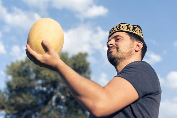 junger Mann mit einer reifen Melone - Foto, Bild