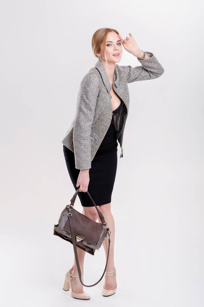 красивая деловая женщина блондинка в черном платье, куртке и сумочках
 - Фото, изображение