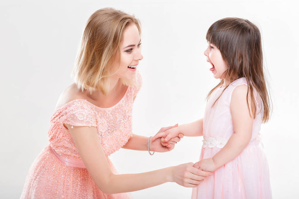 blonde mom comforting daughter in pink dresses princesses. baby - Фото, изображение
