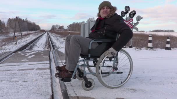 Engelli adam tekerlekli sandalye yakınındaki demiryolu geçişi - Video, Çekim