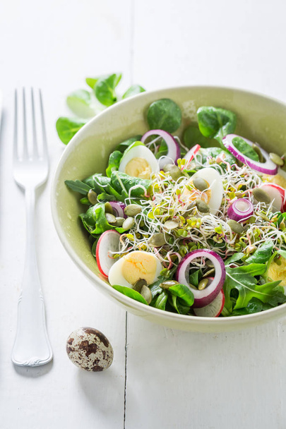 Homemade green salad with quail egg, radish and onion - Foto, afbeelding