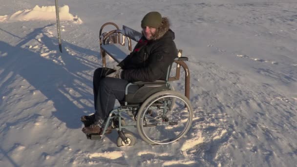 Disabled man on wheelchair talking on phone near bus stop - Footage, Video