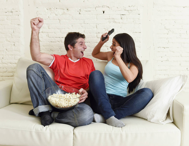 young couple watching tv sport football game excited celebrating - Photo, Image