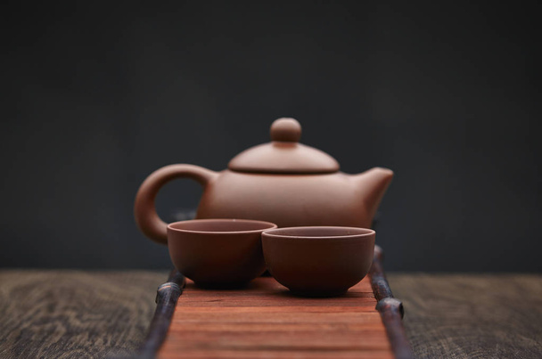 Accesorios tradicionales para la ceremonia del té, tetera con fondo de madera
 - Foto, imagen