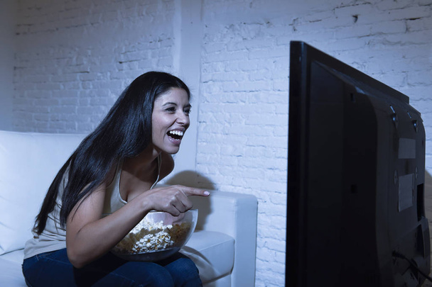 happy woman watching television at sofa couch happy excited enjoying eating popcorn - Photo, Image