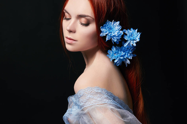 Sexy beautiful redhead girl with long hair in dress cotton retro. Woman portrait on black background. Deep eyes. Natural beauty, clean skin, facial care and hair. Strong and thick hair. Flower - Photo, image
