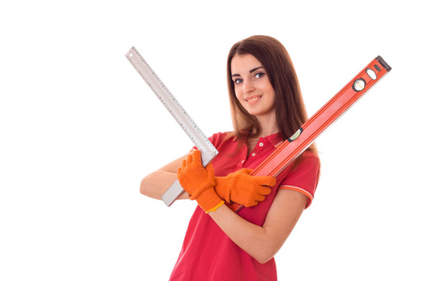 pretty young slim builder girl makes renovations with tools in her hands isolated on white background - Fotó, kép