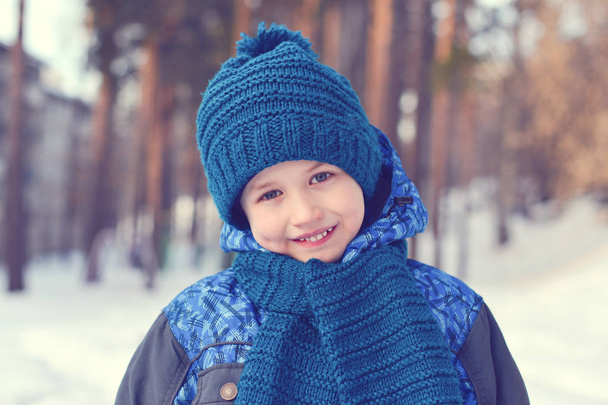 Little boy standing on the winter forest background - Photo, image