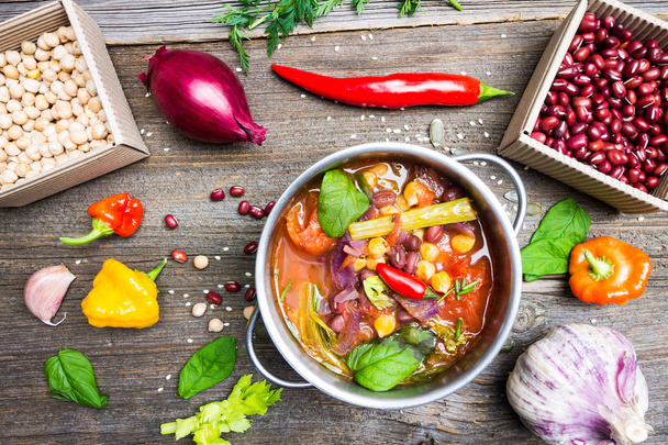 Colorful Food Background. Bio Vegetable Soup with Chickpea and Adzuki Beans in Pot with Cooking Ingredients on Wooden Table. - Fotografie, Obrázek