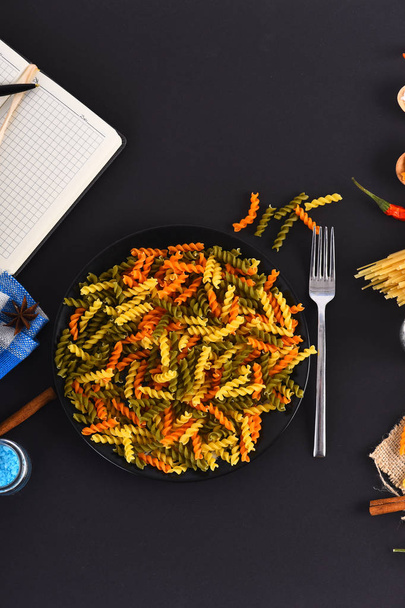 Colorful fusilli in bowl with fork - Valokuva, kuva