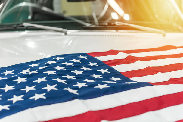 USA flag on the hood of a white car - Foto, afbeelding
