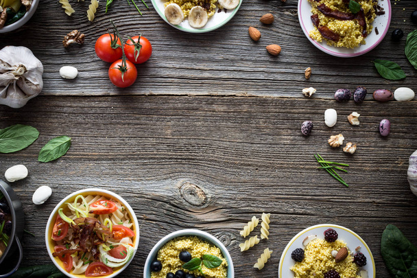 Food and Ingredients with Empty Space for Designs on Wooden Background. Overhead Shot. - Fotó, kép
