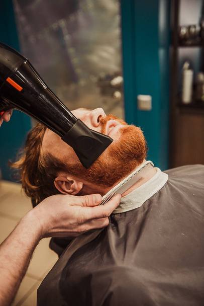 Professional Master hairdresser cuts client beard. Barber Men - Zdjęcie, obraz