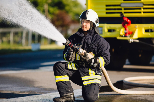 fireman  spilling water in  combustion zone - 写真・画像