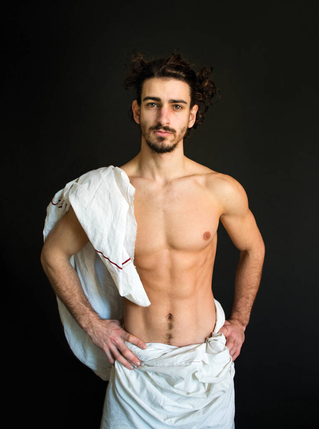 hermoso medio desnudo, barbudo hombre con el pelo rizado en una foto blanca cortina
 - Foto, Imagen