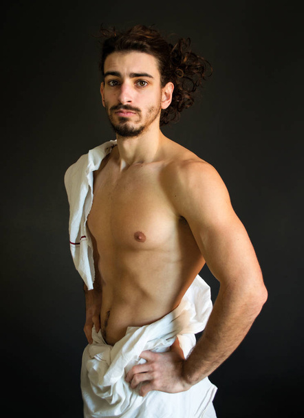 Foto krásné napůl nahý, vousatý muž s kudrnatými vlasy v bílé sukno - Fotografie, Obrázek