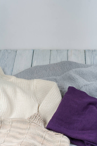 Pile of knitted winter clothes on wooden background, close-up  - Φωτογραφία, εικόνα