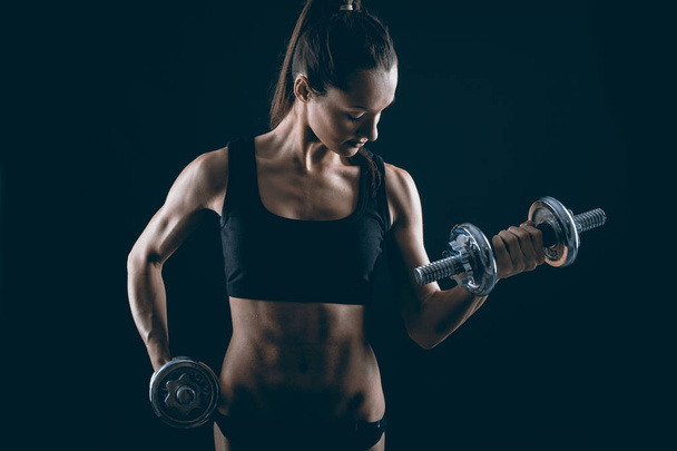  Strong fit woman exercising with dumbbells - Foto, Imagen