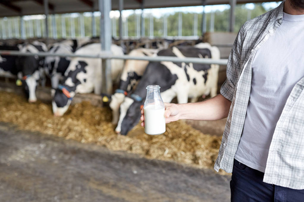 close up of man or farmer with milk on dairy farm - Foto, Bild