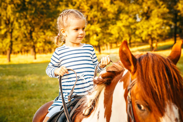 Little girl riding a horse - Zdjęcie, obraz