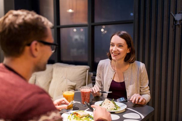 happy couple eating dinner at vegan restaurant - Photo, Image