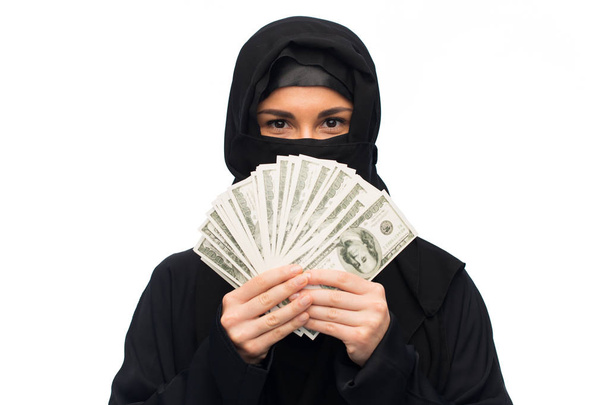 muslim woman in hijab with money over white - 写真・画像