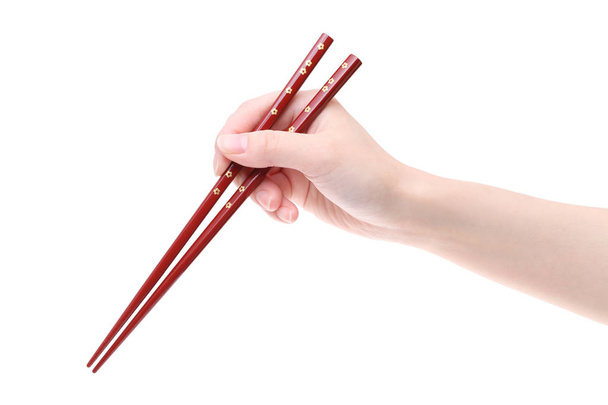 Hand holding wooden chopsticks - Foto, imagen
