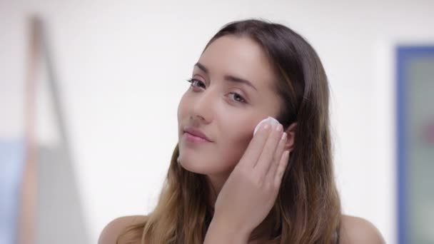 Young attractive woman removes makeup - Felvétel, videó
