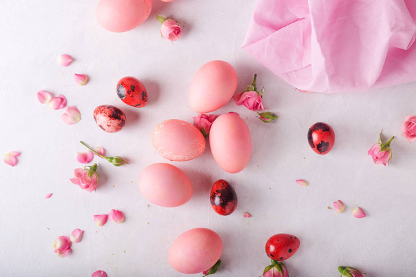 Pink Easter eggs on light background. Copyspace. Still life photo of lots of pink easter eggs.Background with easter eggs. Pink eggs and roses. Easter photo concept  - 写真・画像