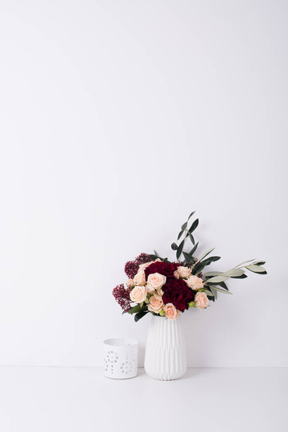roses and carnations in a vase in white interior - 写真・画像