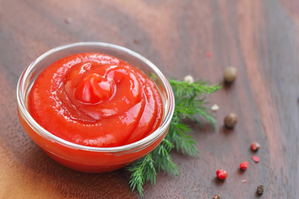 Salsa de tomate ketchup con condimentos en un tazón de vidrio
 - Foto, imagen