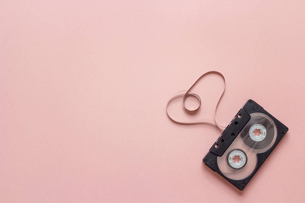 Audio cassette tape in the shape of heart on pink background.  - Photo, image