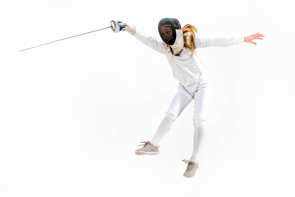 Man wearing fencing suit practicing with sword against gray - Foto, Imagem