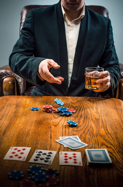The man, chips for gamblings, drink and playing cards - Photo, Image