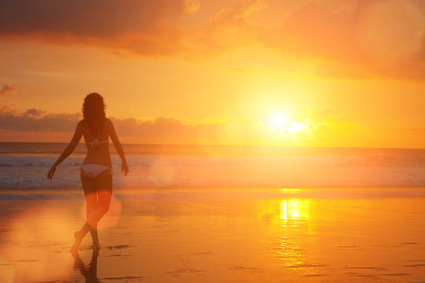 Σιλουέτα της γυναίκας για το ηλιοβασίλεμα. Πολύχρωμο αυγή πάνω από τη θάλασσα. Ομορφιά της φύσης. Ανέμελη γυναίκα απολαμβάνοντας το ηλιοβασίλεμα στην παραλία. Χαρούμενη ζωή - Φωτογραφία, εικόνα