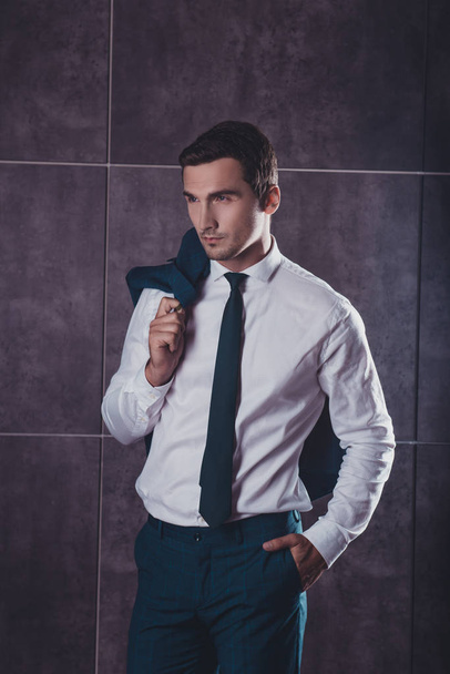 Portrait of young successful handsome businessman holding jacket - Photo, Image