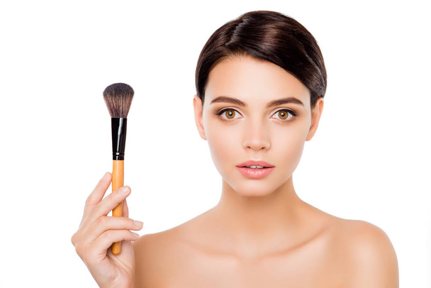 Portrait of young sensitive pretty woman showing make-up brush - Photo, image
