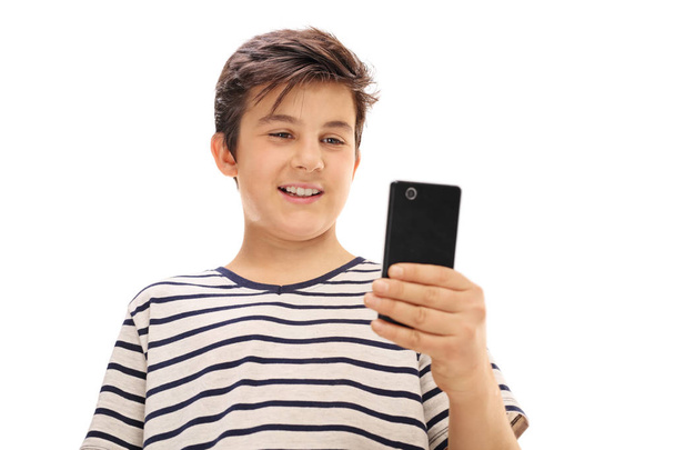 Boy looking at a phone and smiling - Valokuva, kuva