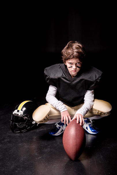 Boy playing american football - Foto, afbeelding