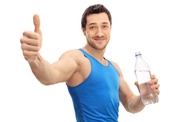 Guy holding bottle of water and making thumb up gesture - Foto, imagen
