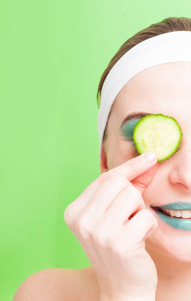 Vrouw met komkommerschijfje in de ogen  - Foto, afbeelding