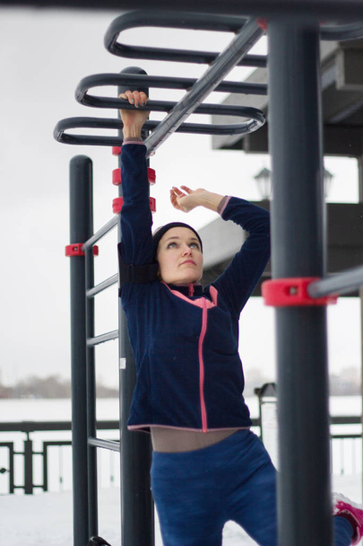 junge Sportlerin macht Kraftübungen bei Work-out Fitness im Snow Winter Park - Foto, Bild