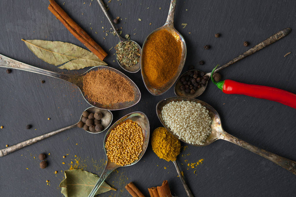 circle of spoons with different colored spices - 写真・画像