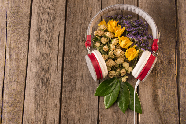 ακουστικά και τα λουλούδια στο τραπέζι  - Φωτογραφία, εικόνα