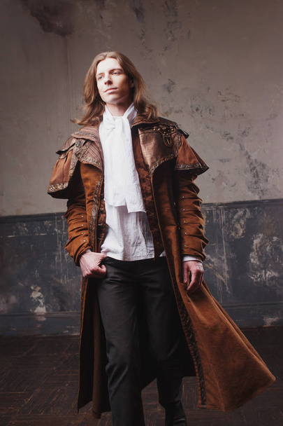 Handsome male in brown cloak, Steam punk style. Retro man portrait over grunge background. - Foto, Imagen