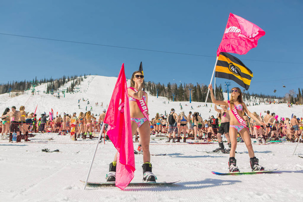 Group of young happy pretty women on a snowboard in colorful bikini with flags. - 写真・画像