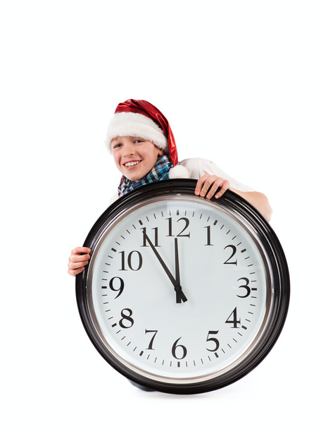 Teenager in cap of Santa Claus and large clock, isolation - Φωτογραφία, εικόνα